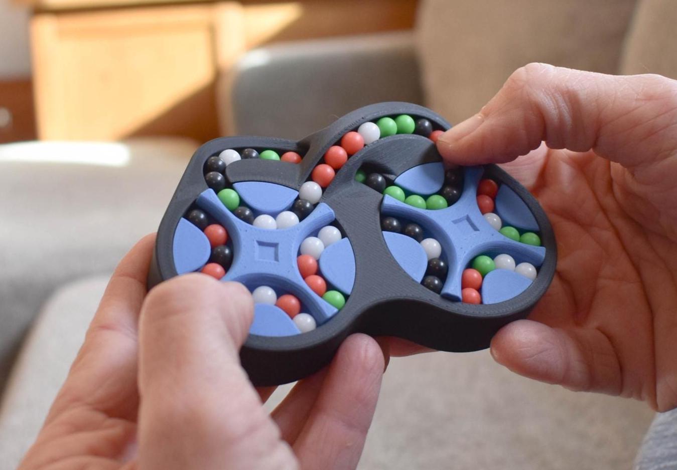 Four-color figure-eight mechanical puzzle fidget with colorful beads in black frame hands-held brainteaser. - andEleven - The Figure-Eight (4-Color)