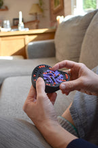 Black and purple heart-shaped mechanical puzzle held as a brainteaser fidget toy. - andEleven - The Taurus (2-Color)