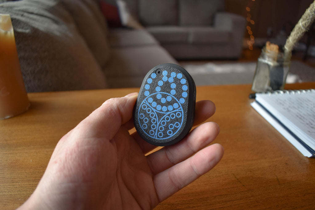 Small oval mechanical puzzle with blue bead maze design held in hand, fidget brainteaser toy. - andEleven - The Pretzel
