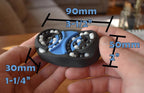 Compact black and blue mechanical puzzle with rotating parts, held between fingers, brainteaser and fidget toy. - andEleven - The Butterfly