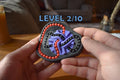 Two-color mechanical puzzle with interlocking black and purple pieces and orange beads, held in hands, brainteaser fidget. - andEleven - The Taurus (2-Color)