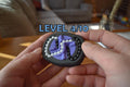 Small black and purple mechanical puzzle brainteaser fidget held in hands with visible level 4/10 indicator. - andEleven - The Infinity (2-Color)