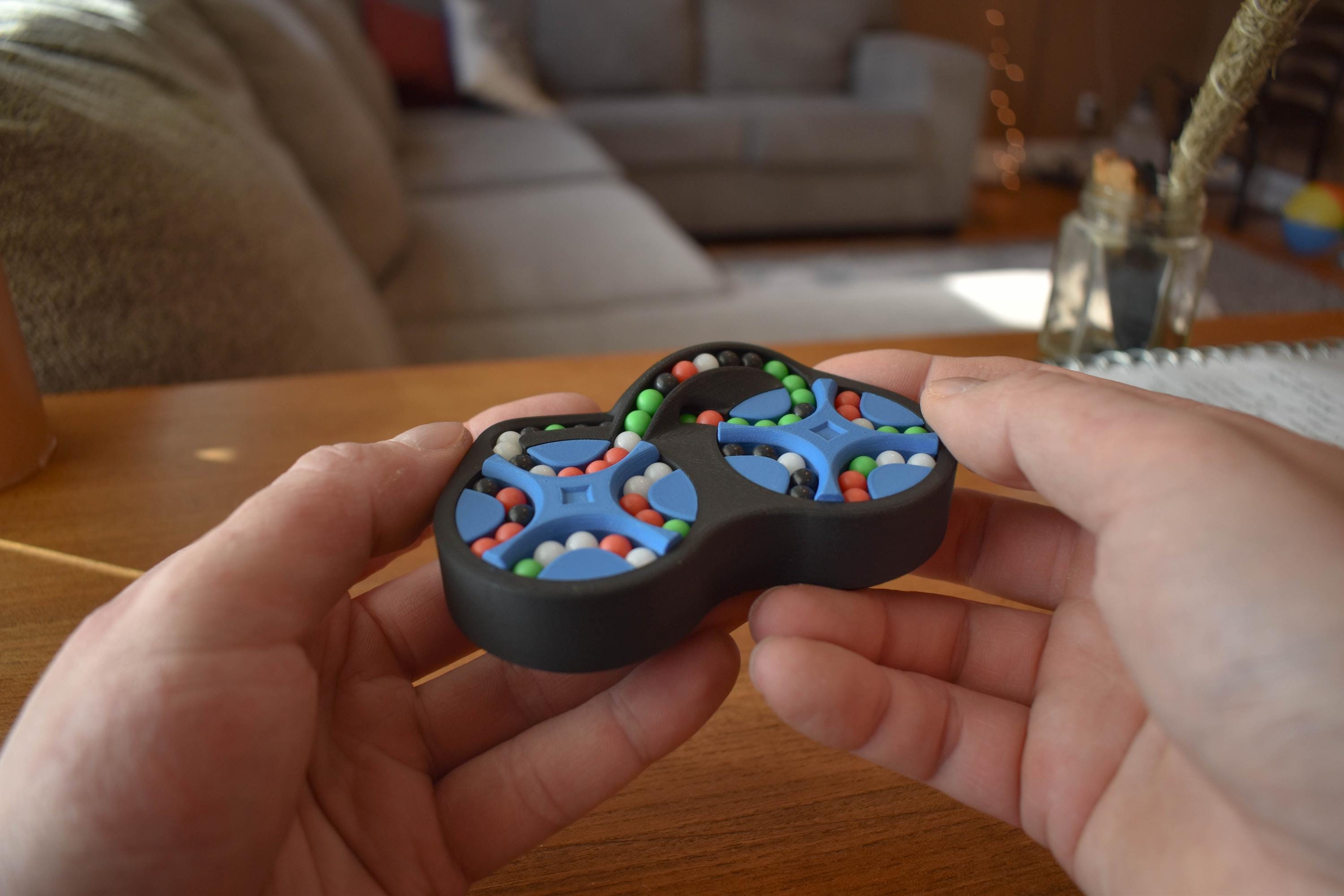 Black handheld mechanical puzzle brainteaser with colorful beads for fidgeting. - andEleven - The Figure-Eight (4-Color)