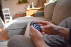 Hands holding a blue and black Pretzel mechanical puzzle brainteaser fidget on a cozy couch. - andEleven - The Pretzel
