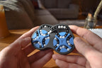 Two-color blue and black mechanical puzzle with rotating gears held in hands, brainteaser fidget toy. - andEleven - The Figure-Eight (2-Color)