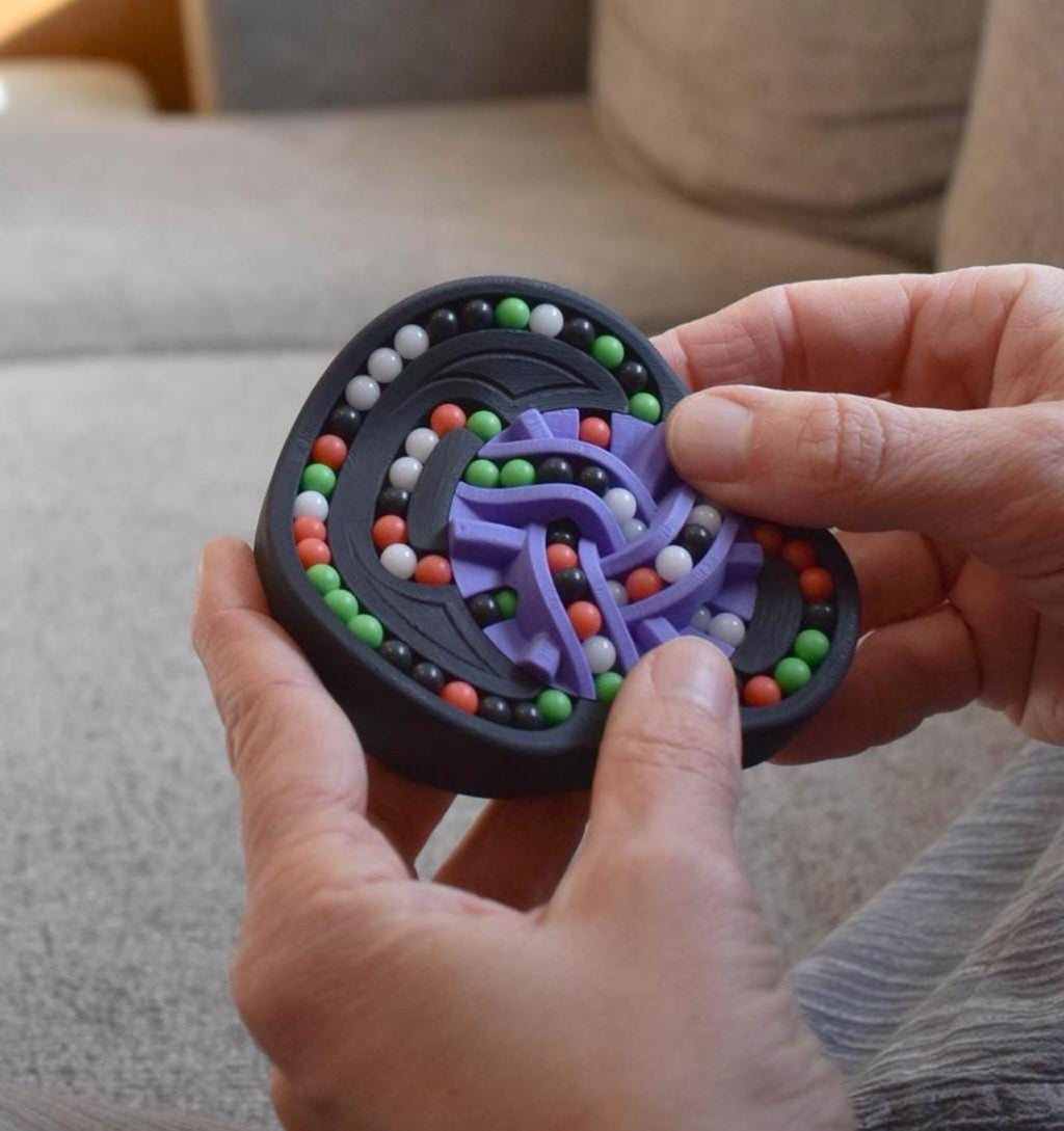 Compact circular mechanical puzzle featuring colorful beads and interlocking purple tracks, ideal brainteaser fidget toy. - andEleven - The Taurus (4-Color)