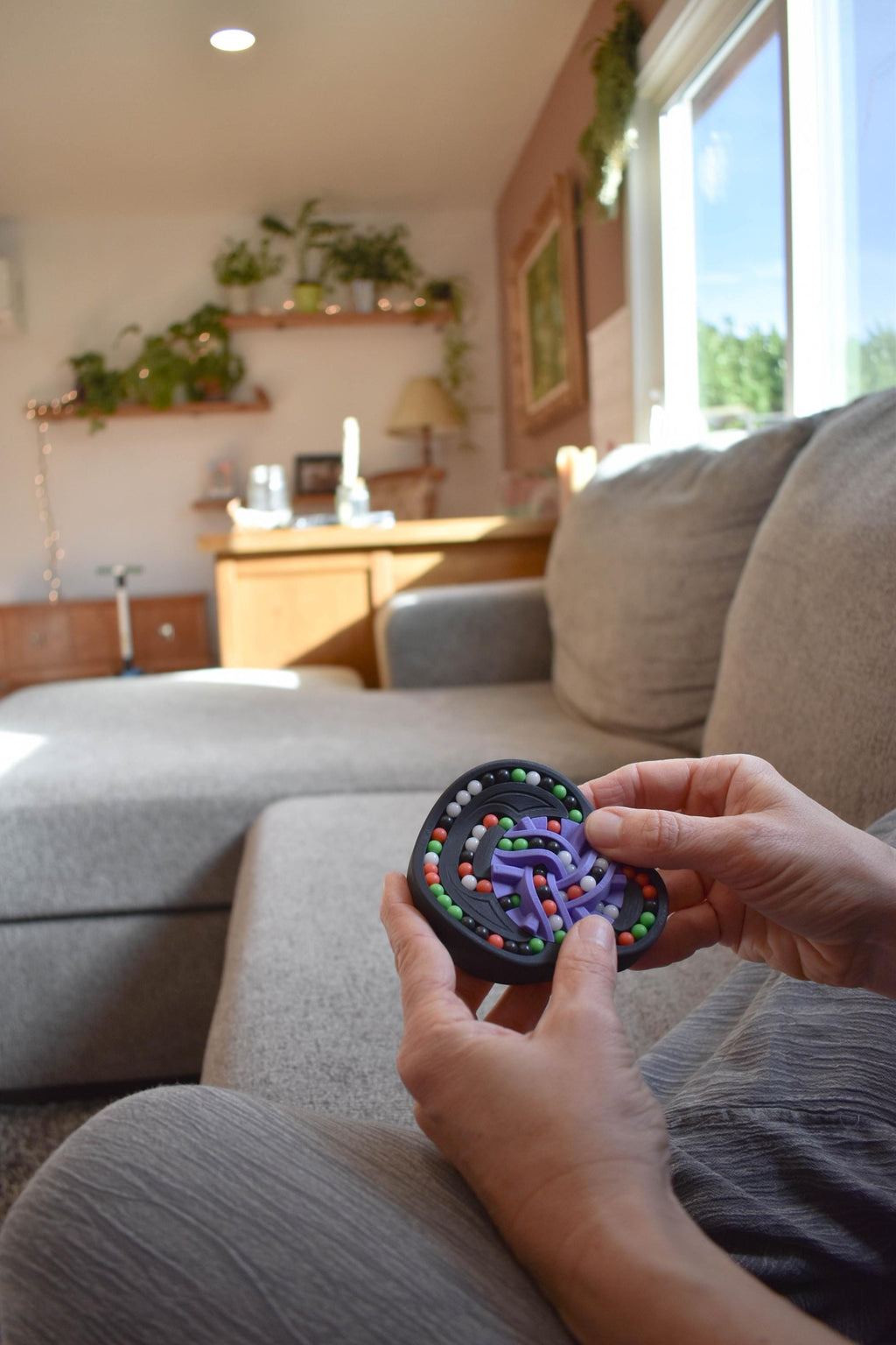Colorful circular mechanical puzzle brainteaser fidget held in hands on sofa in bright cozy room. - andEleven - The Taurus (4-Color)