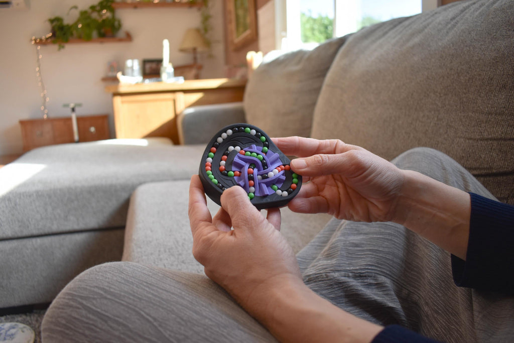 Hands holding a colorful mechanical puzzle brainteaser with interlocking pieces, perfect fidget toy. - andEleven - The Taurus (4-Color)