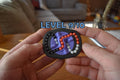 Compact black mechanical puzzle with purple, orange, and pink pieces, held in hands, labeled Level 9/10 brainteaser fidget. - andEleven - The Infinity (3-Color)