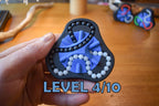 Blue and black triangular mechanical puzzle brainteaser with white beads held in hand, fidget toy level 4/10. - andEleven - The Delta (2-Color)