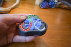 Triangular mechanical puzzle fidget with four colorful bead tracks and black base held in hand. - andEleven - The Delta (4-Color)