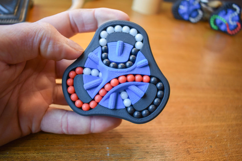 Triangular mechanical puzzle with black frame, purple base, and red and white beads for brainteaser fidget play. - andEleven - The Delta (3-Color)
