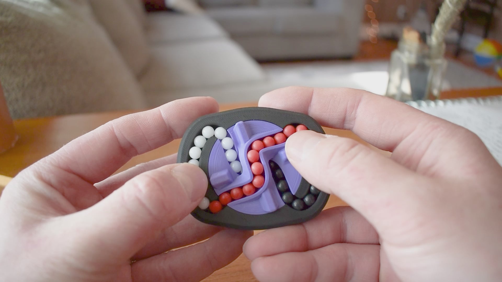 A person trying to solve the product by cycling the balls through the tracks, and turning the center rotor. The rotor makes a satisfying snap is it clicks in to place.