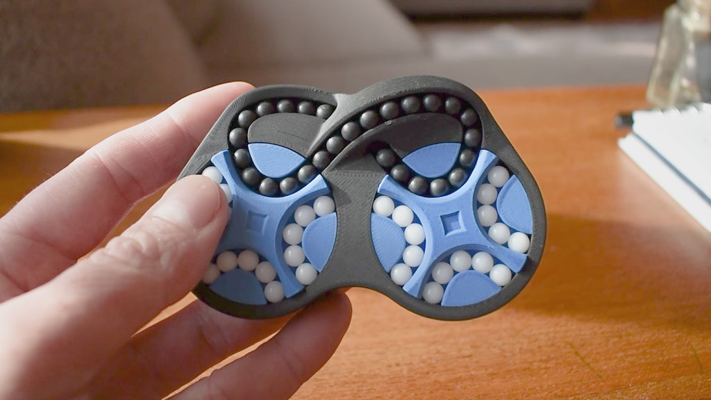 A person trying to solve the product by cycling the balls through the tracks, and turning the center rotor. The rotor makes a satisfying snap is it clicks in to place.