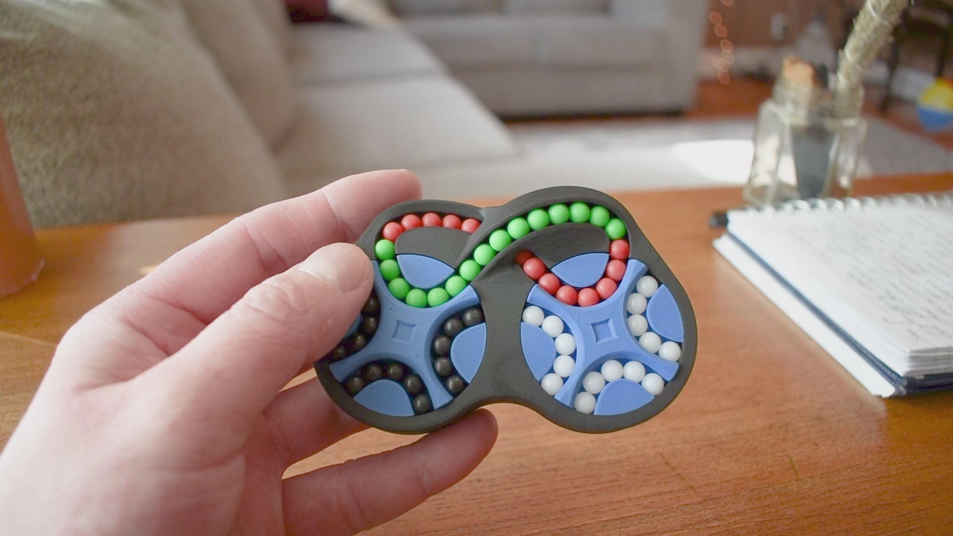A person trying to solve the product by cycling the balls through the tracks, and turning the rotors. The rotors make a satisfying snap as they clickin to place.