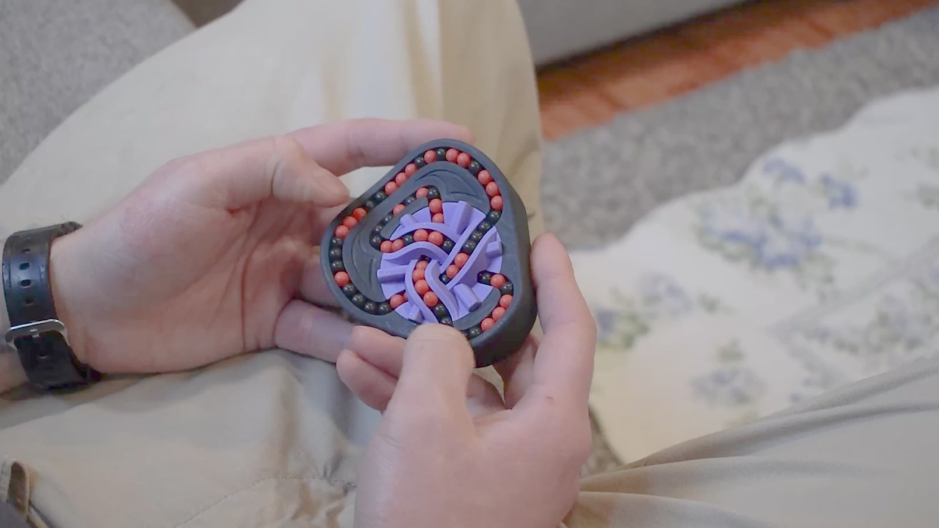 A person trying to solve the product by cycling the balls through the tracks, and turning the center rotor. The rotor makes a satisfying snap is it clicks in to place.