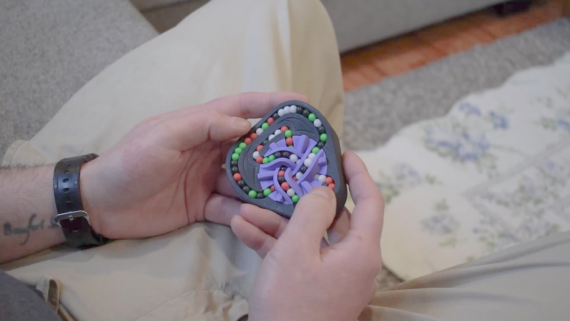 A person trying to solve the product by cycling the balls through the tracks, and turning the center rotor. The rotor makes a satisfying snap is it clicks in to place.