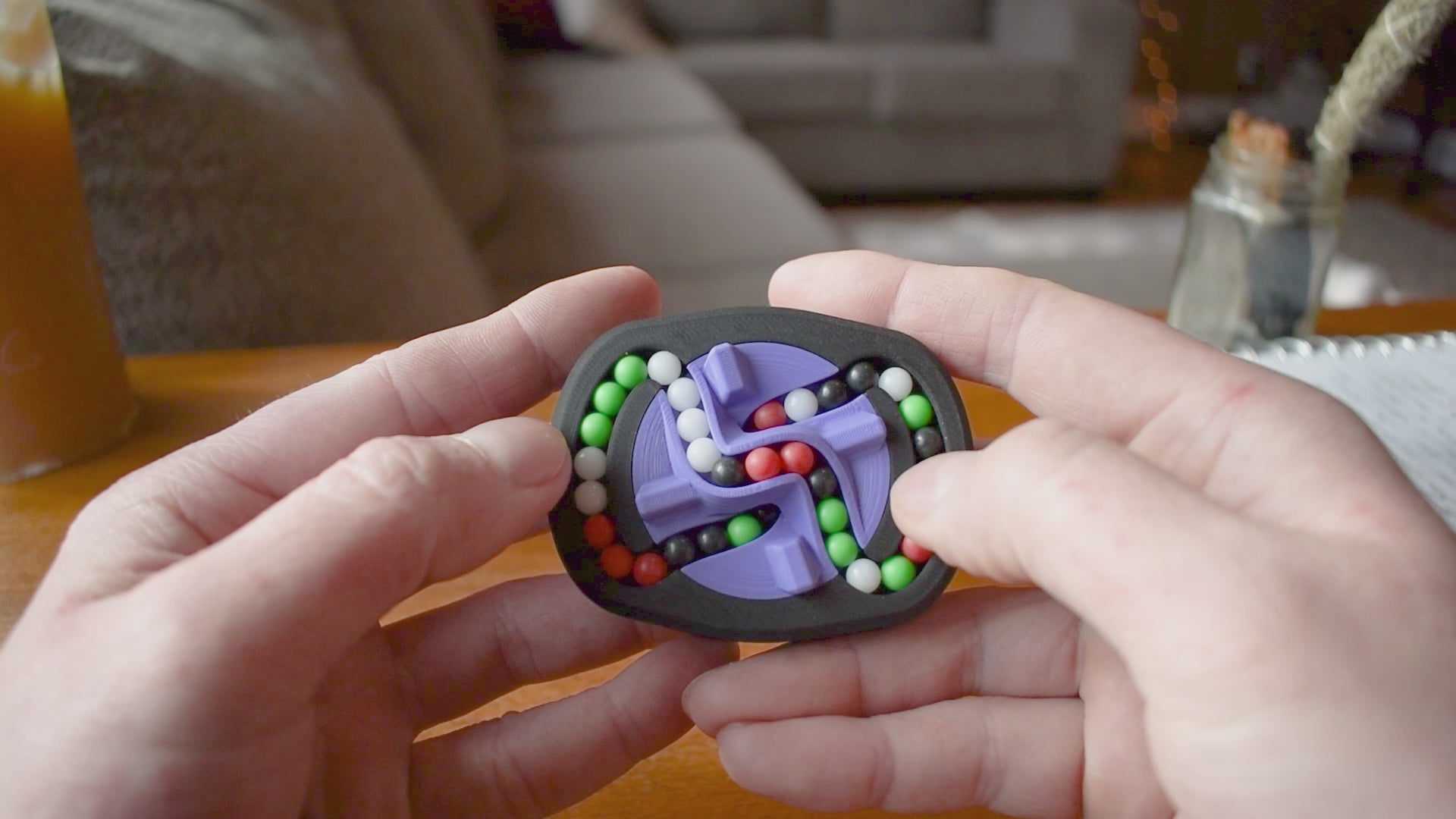 A person trying to solve the product by cycling the balls through the tracks, and turning the center rotor. The rotor makes a satisfying snap is it clicks in to place.