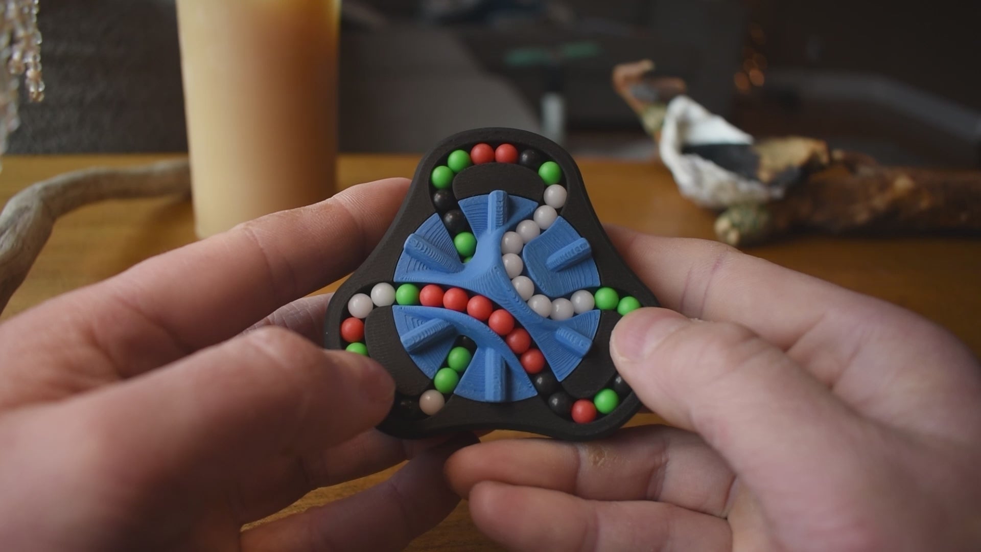 A person trying to solve the product by cycling the balls through the tracks, and turning the center rotor. The rotor makes a satisfying snap is it clicks in to place.